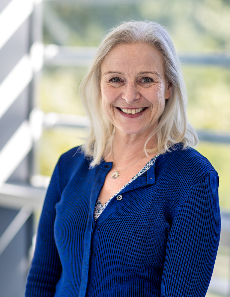 Photo of a smiling woman with a blue cardigan