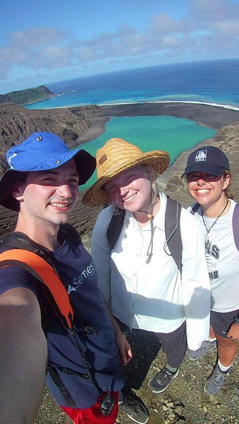 Cameron, Grace, and Natalie (left to right) at the rim of the Crater Lake. The Crater Lake and the South Shore of HTHH can be seen behind them. Credit: SEA