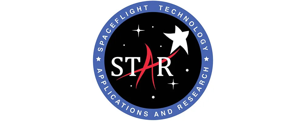 The image is a circular logo with a blue outer ring and a black inner circle. The blue outer ring contains the text "SPACEFLIGHT TECHNOLOGY APPLICATIONS AND RESEARCH" in white, capital letters, with five small white stars evenly spaced along the ring. The black inner circle features the acronym "STAR" in large, white, and red capital letters. The letter "A" in "STAR" is stylized with a red arrow extending upwards. Above the "A" is a white star, and there are three smaller white stars scattered around the inner circle.