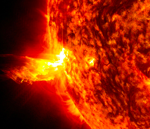 This image from June 20, 2013, at 11:15 p.m. EDT shows the bright light of a solar flare on the left side of the sun and an eruption of solar material shooting through the sun’s atmosphere, called a prominence eruption.