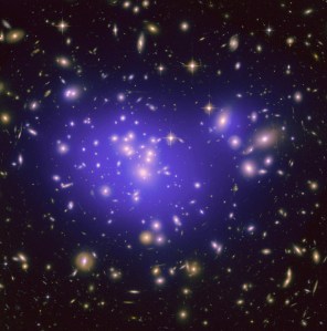 A cluster of galaxies fills the frame. A purple glow around the largest concentrations of galaxies indicates the distribution of dark matter.