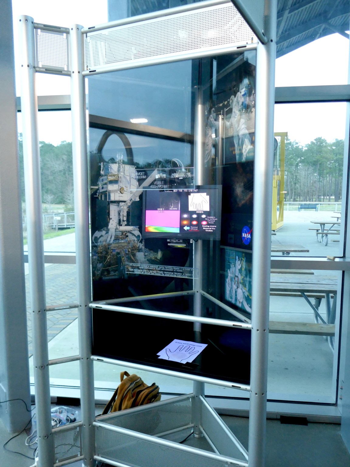 An interactive exhibit where a visitor puts their hand under a camera and they see it on the screen in ultraviolet, visible, and infrared light.