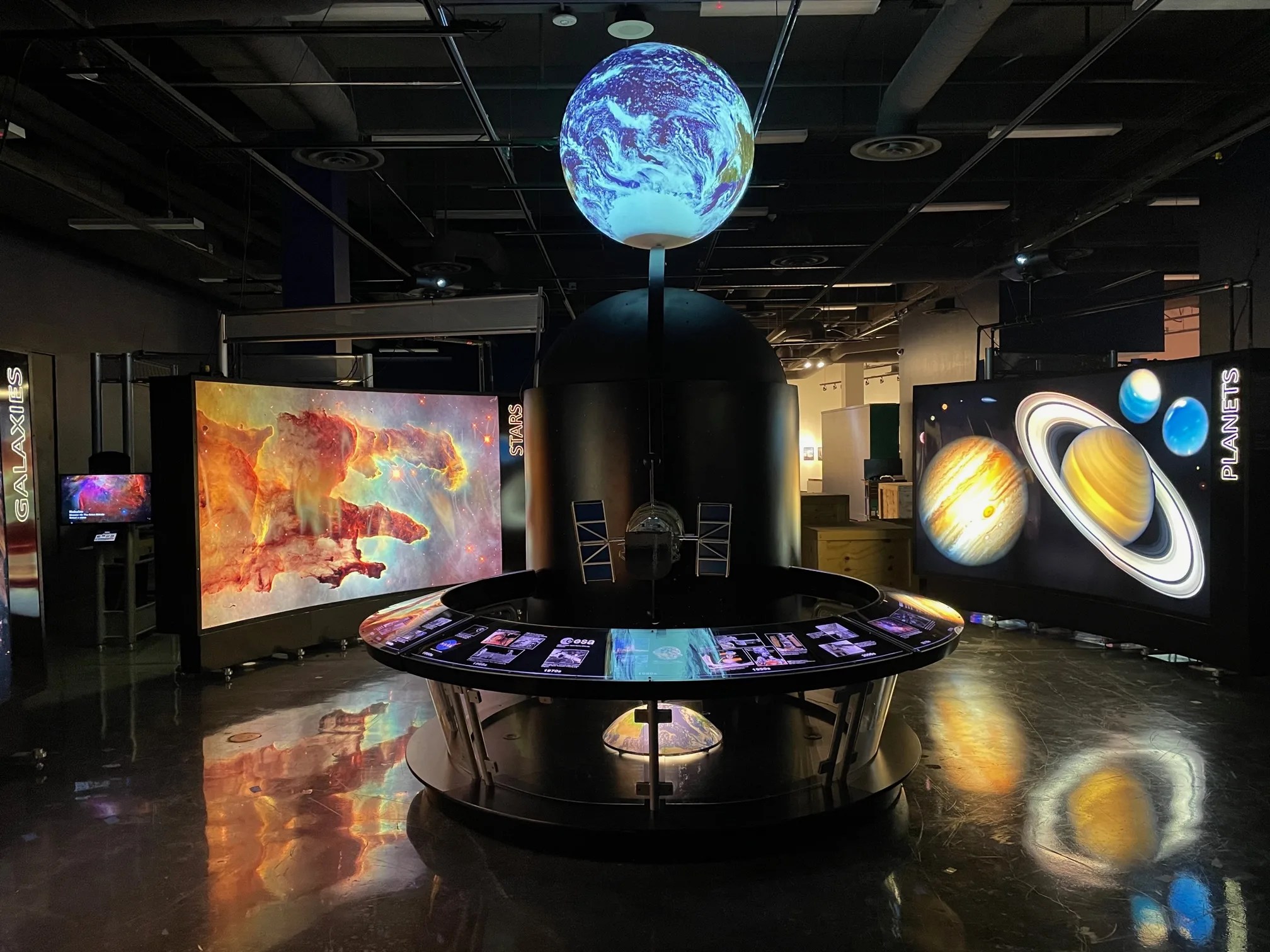 A 3-foot sphere is illuminatedabove the centerpiece station with the earth projected onto it.