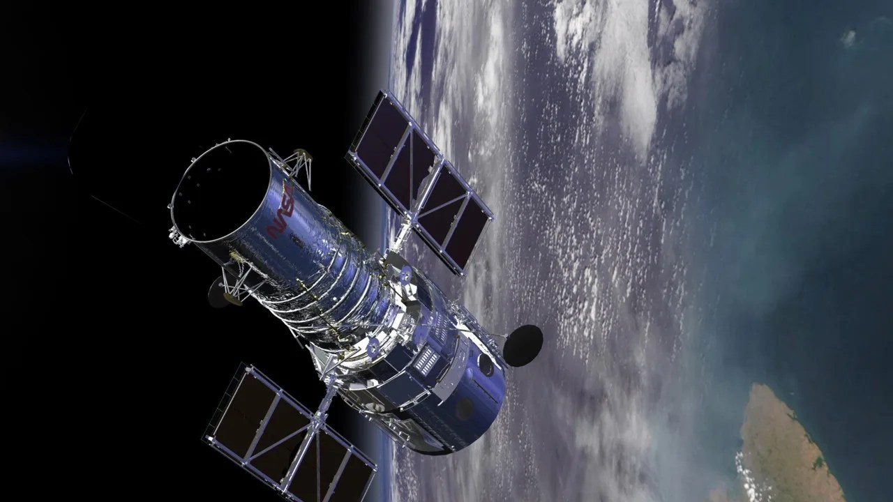Animated image of the Hubble Space Telescope, moments before it will fly by the viewer. Under Hubble you can see the Earth, dark blue from an Ocean, with a large green body of land to the left.
