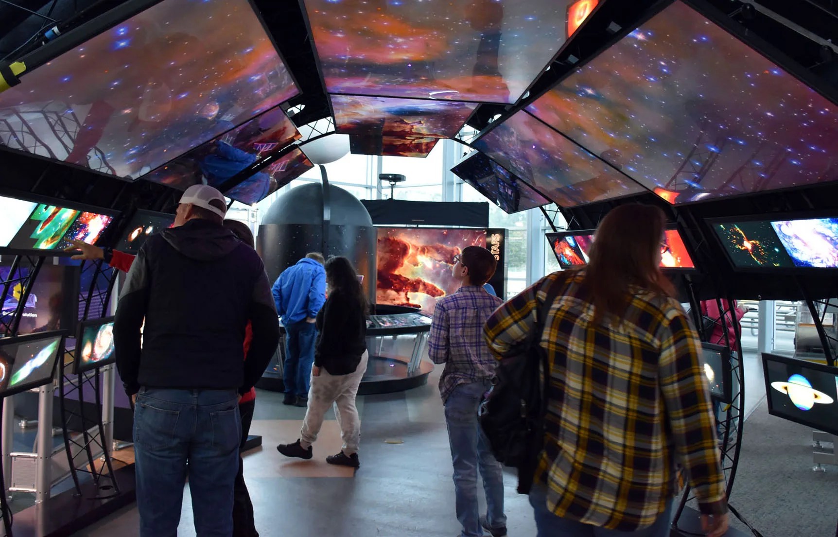 People walking through a tunnel of images at the entry way to the HST traveling exhibit.