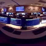 360 image of Hubble's "Space Telescope Operations Control Center" The image is stretched because it is designed for 360 degree viewing. The image shows many desks within the control center with data on their screens.