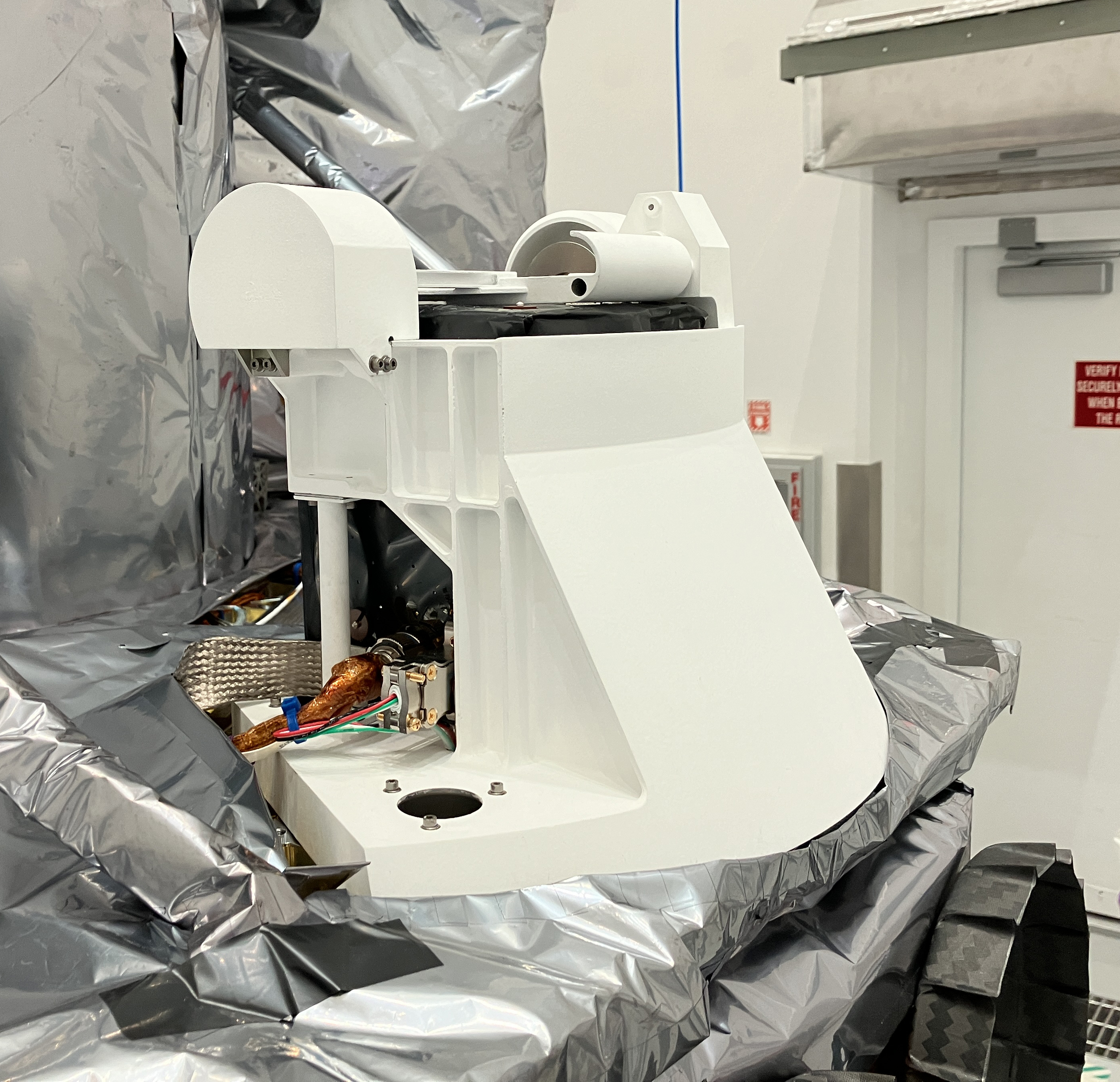 A lab scientist works with the the PITMS instrument which has been integrated onto the Astrobotic Peregrine lander.