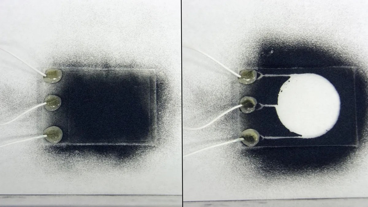 Two glass test slides side-by-side. One is covered in a simulated Moon dust while the other, covered by the EDS, shows protection from the same Moon dust.