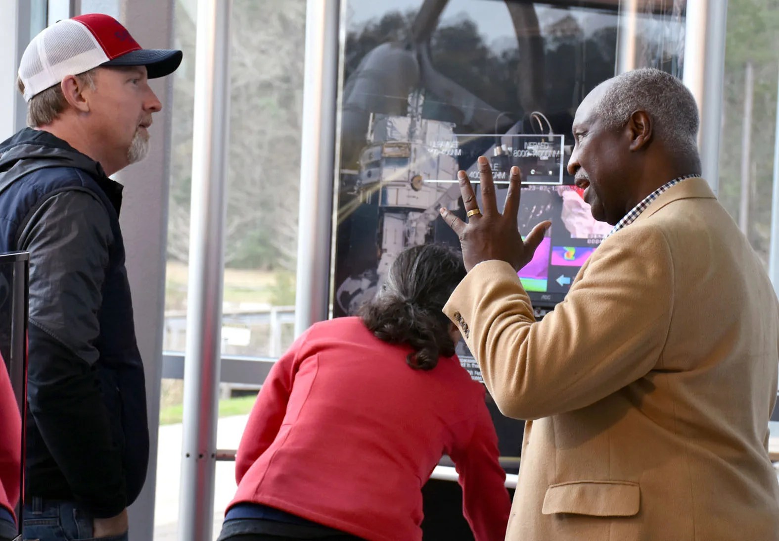 A HUbbe Team member explains the wavelengths of light to visitors at an interactive light station that is part of the Hubble traveling exhibit.