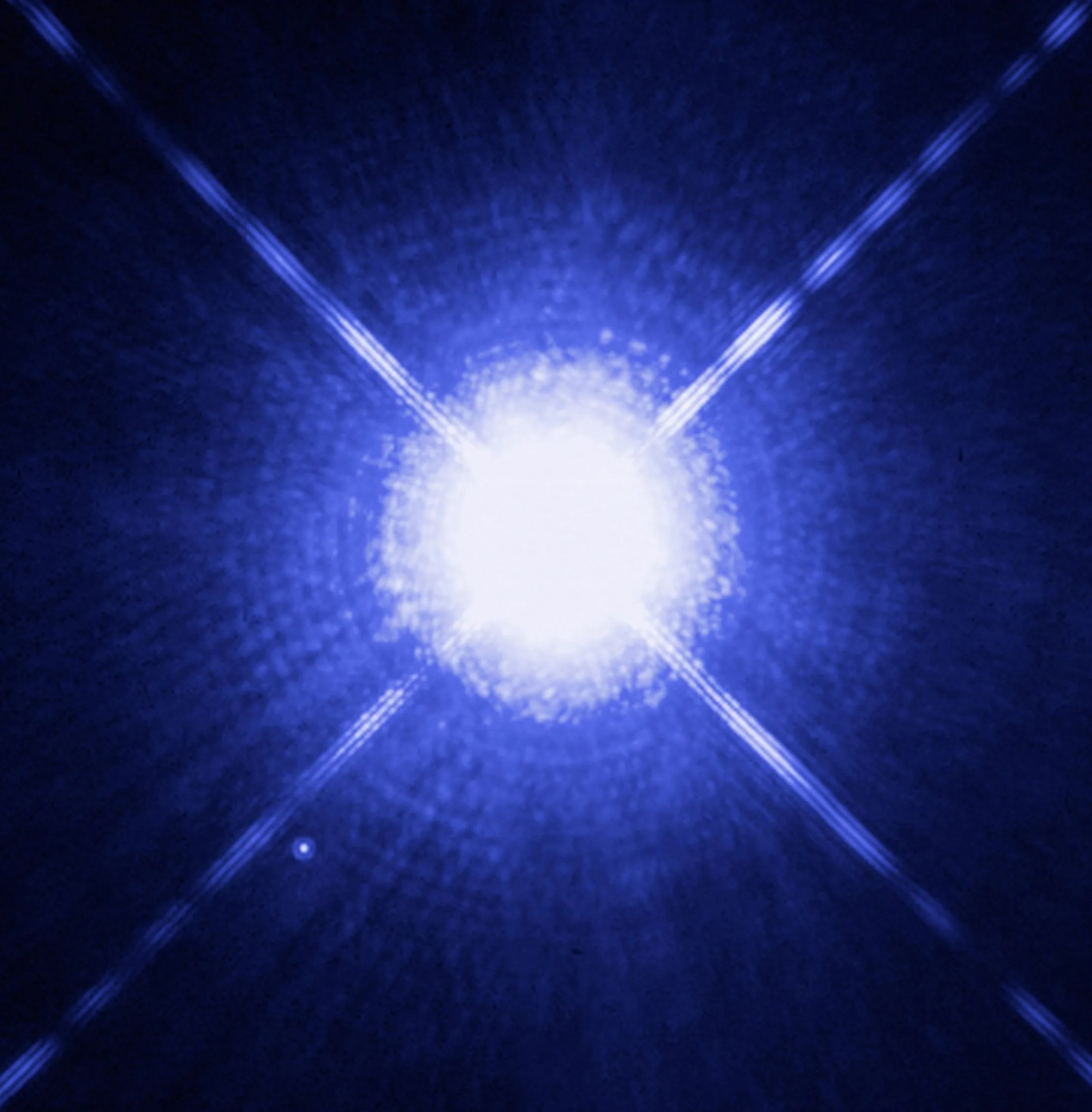 Brilliant closeup burst of white light radiating outward against deep space