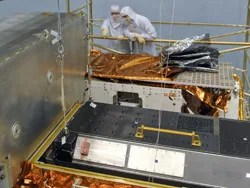 Astronauts watch while engineers inside the goddard cleanroom pull the cosmic origins spectrograph instrument from its protective enclosure.  the spectrograph is scheduled to be installed on hubble during servicing mission 4 next summer.