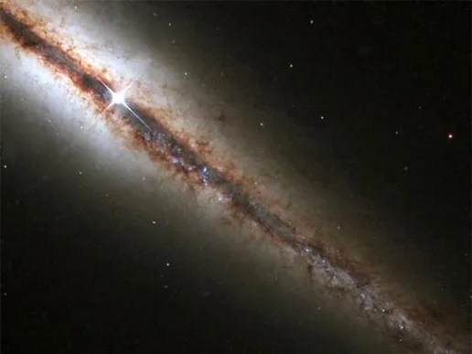 An amazing edge-on view of a spiral galaxy 55 million light years from Earth, captured by the Hubble Space Telescope