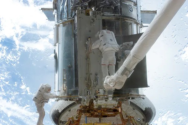 Astronauts perform upgrades on the telescope during a spacewalk in the 2002 servicing mission