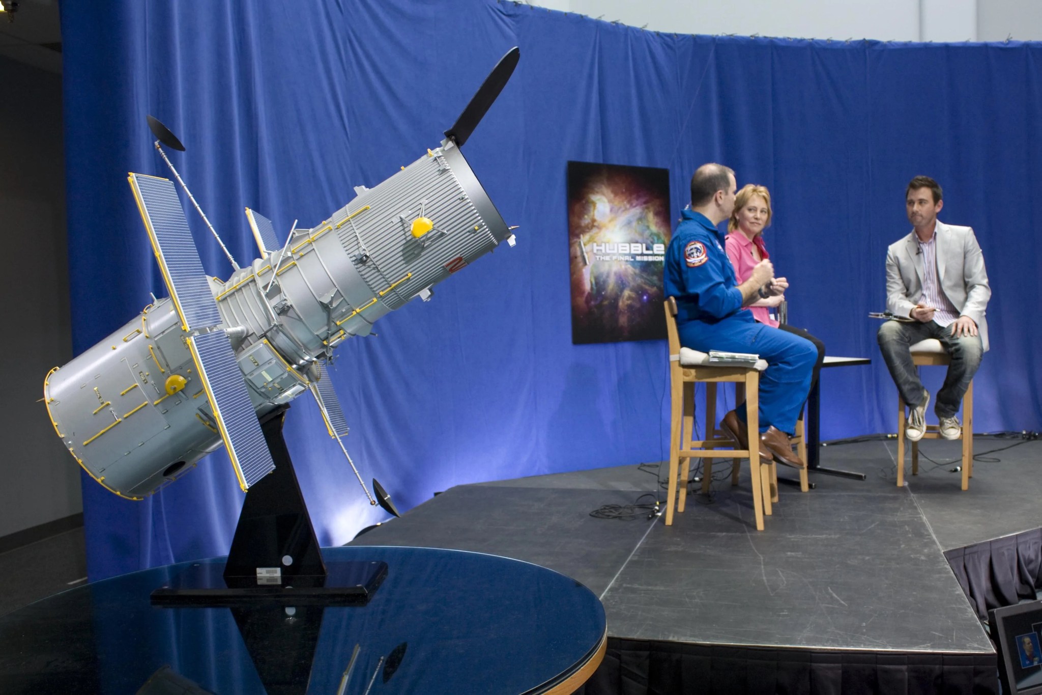 Photo of a Hubble model with astronaut Paul Richards (left) and Dr. Kim Weaver in the background.