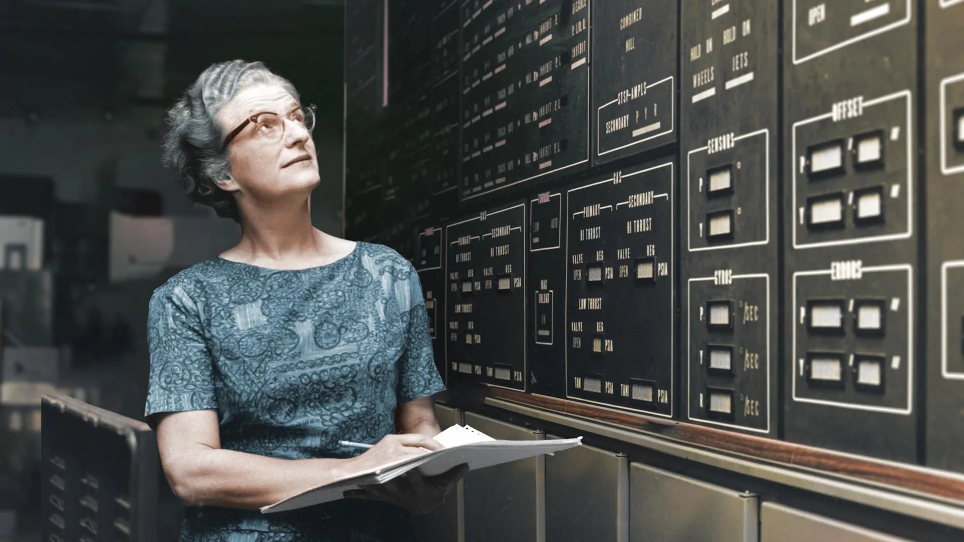 Nancy Grace Roman stands in front of a board that contains electronic spacecraft information.