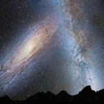 illustration of merging galaxies in night sky with rocky landscape silhouette in foreground