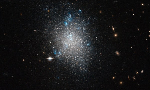 A central scattering of fine stars with a breakouts of blue and background galaxies shining through