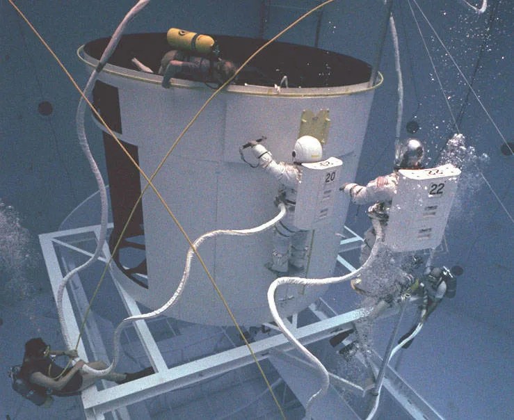 Two astronauts in training underwater.