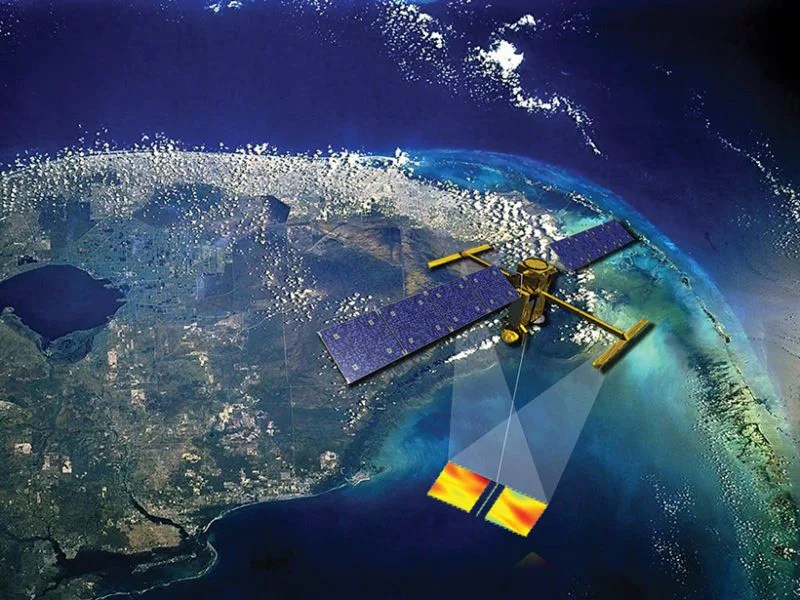 An artist’s impression of the future SWOT satellite making sea surface observations from space with a slightly cloud-covered Earth below.