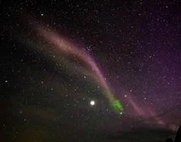 Steve (strong thermal emission velocity enhancement) is seen as a thin purple ribbon of light.