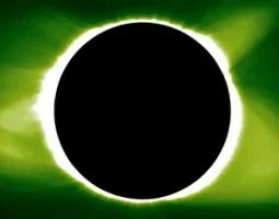 Total solar eclipse against against a light and dark green sky.