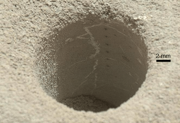 ChemCam laser analysis pits form a line inside the hole drilled by the Curiosity rover in the Sheepbed Mudstone. Each laser pit was produced by 30 laser shots, each with an energy of 14 milliJoules. The hole is about the size of a US dime and was shot from about 2.5 meters distance. Credit: NASA/JPL-Caltech/MSSS.