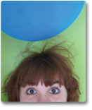 A photo of a balloon above Hannah's head. Static electricity causes her hair to raise 2-3 inches toward the balloon.