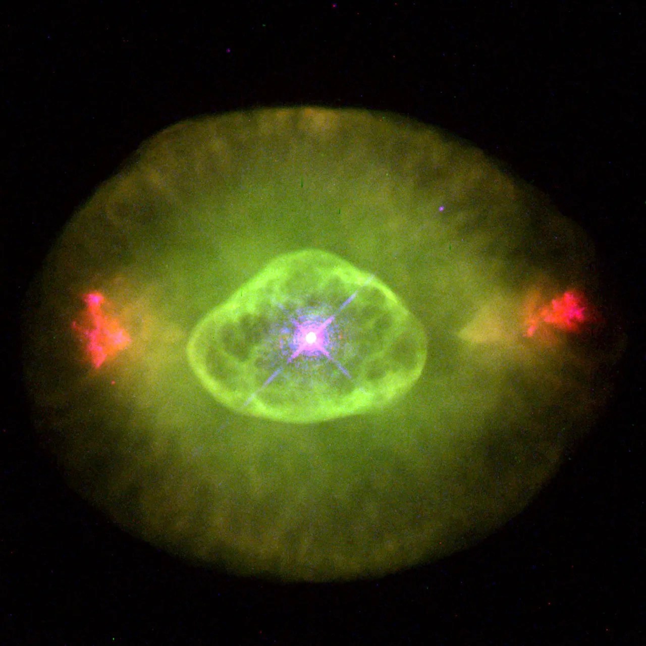 Bright green dust and gas surrounds an inner shell of tightly wound dust and gas, in the center of it all is a bright purple star.
