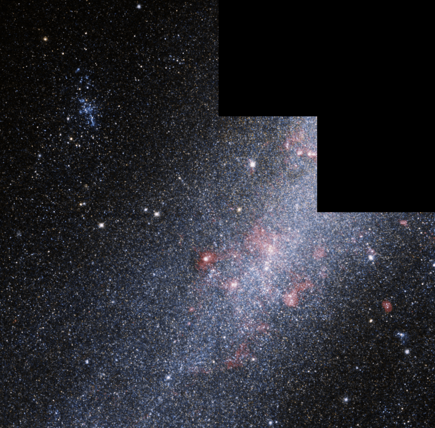 Large grouping of bright white, blue and red stars. Lightly colored blue dust surrounds the stars.