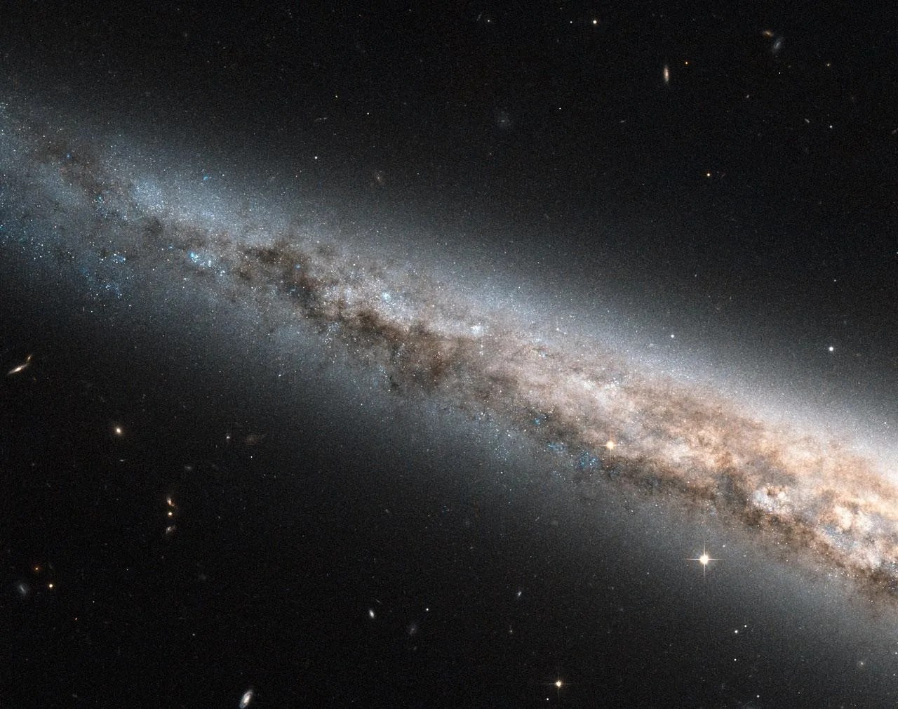 A small section of the outer arm of a galaxy viewed almost edge on. Lots of dust and gas intermixed with stars.