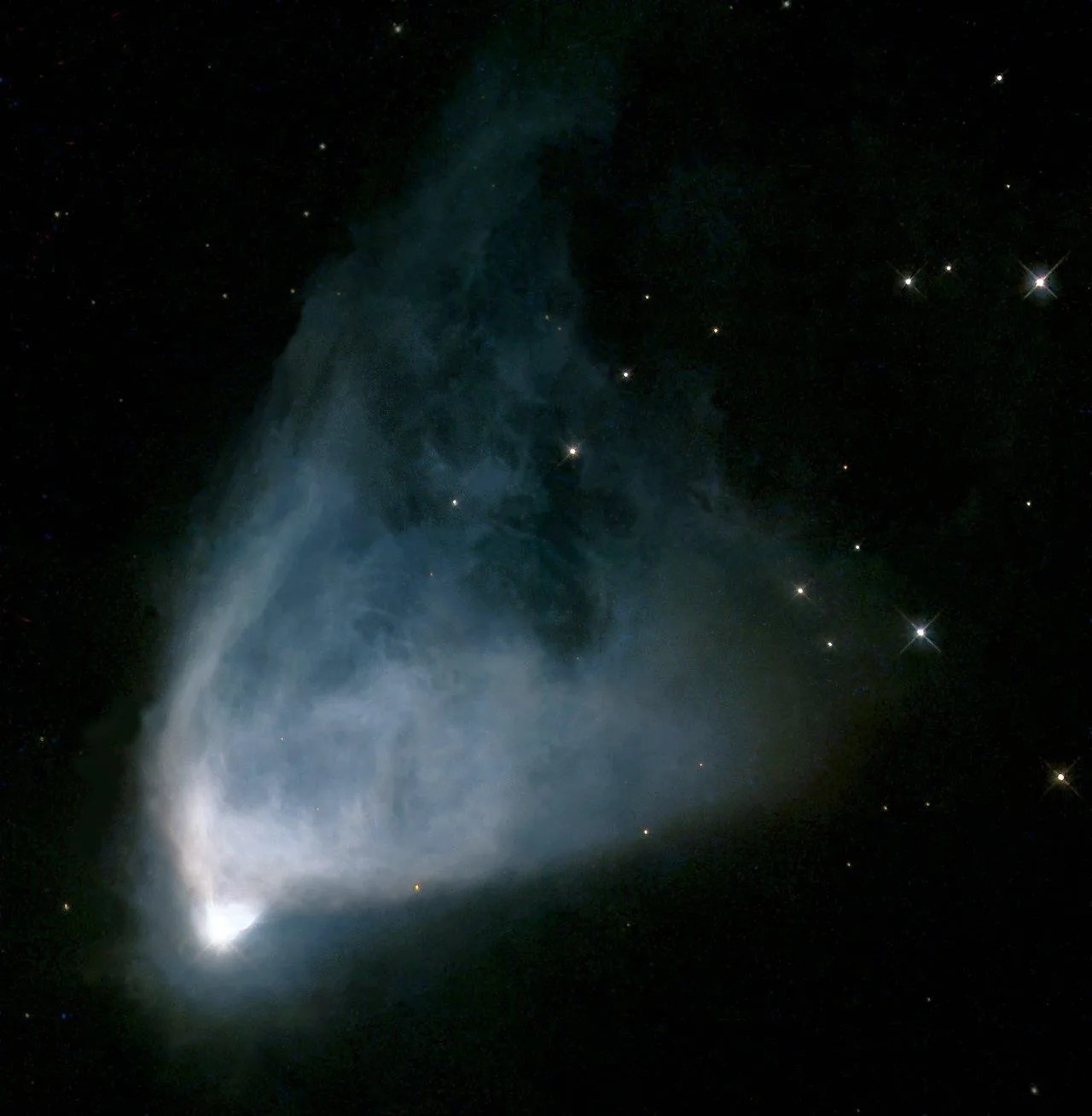 This nebula is shaped like a fan, with the star glowing white in the bottom left. Trailing upwards away from it, like a veil, the gas and dust is bluish-white closest to the star, then turns to a light blue farther away, and then to a deep turquoise at the ends, which are on the top right.