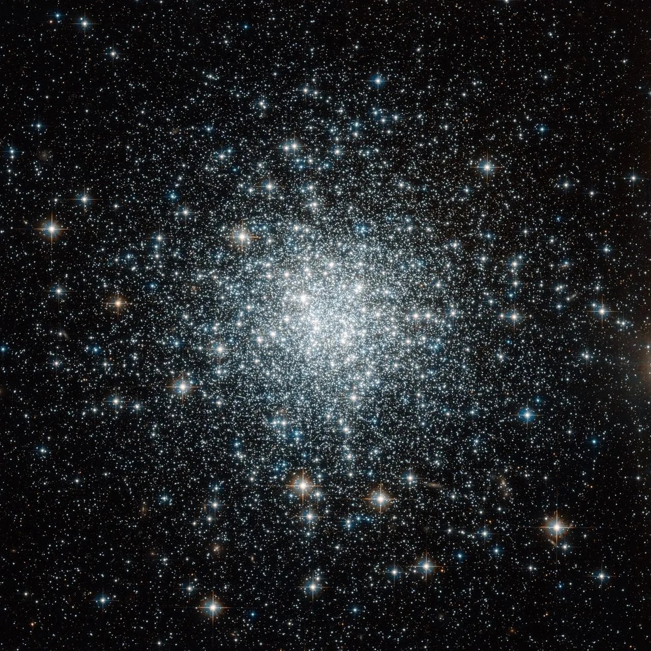This is a globular cluster, a sphere of tens of thousands of stars. Most of them are a whitish color, and more concentrated in the center of the sphere. As you move farther from the center, there are fewer stars.