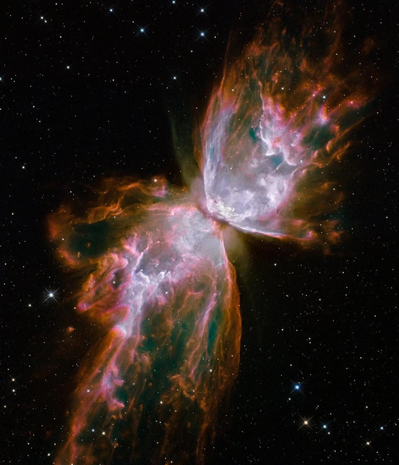 Two lobes of gas and dust expand outward from the center toward the lower left and upper right of the image. The center of each lobe is bright-white ringed by a rose-pink and then a rusty, orang-brown. The nebula is on a black background dotted with stars.