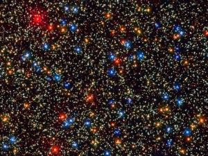 A field shows closely packed yellow, blue and red stars against the black background of space.