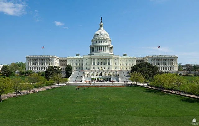 U.S. Capitol: Green lawn stretches to the large, white, domed building.