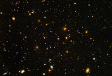 Field is filled with galaxies in colors of white, yellow, blue-white, and red; all on a black background.