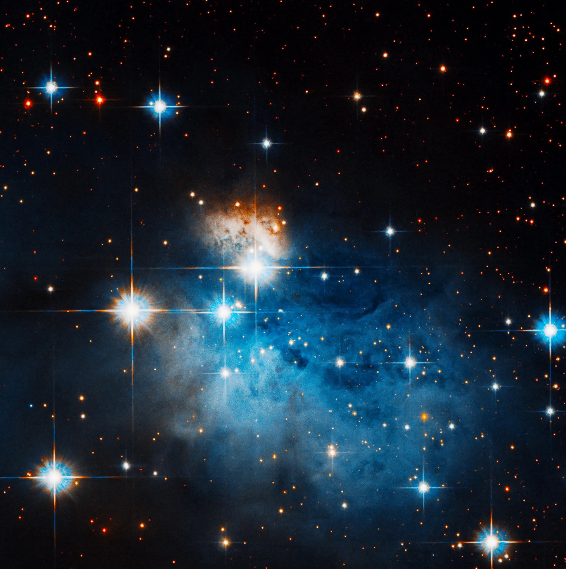 A handful of bright stars amidst and around a blue misty blob of glowing gas.