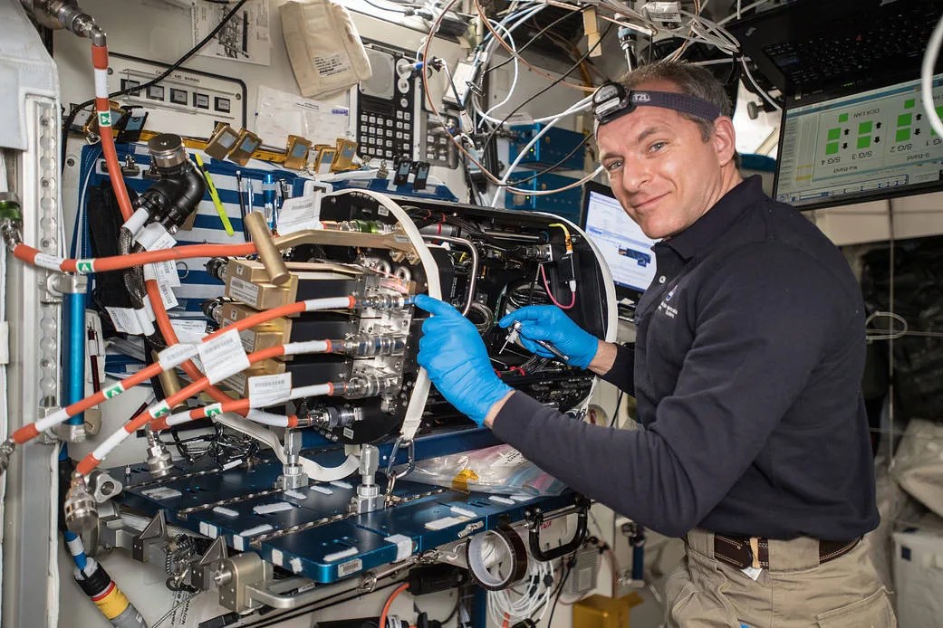 Astronaut David St. Jacques of the Canadian Space Agency works on the Combustion Integrated Rack (CIR) used in the ACME Flames Project.