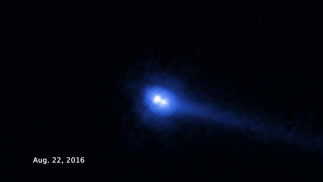 Animation of a binary asteroid with a shifting tail. White asteroid is at image center and is rotating. A blue tail extends away from the asteroid and is rotating counterclockwise from the right to upper-left of the image.