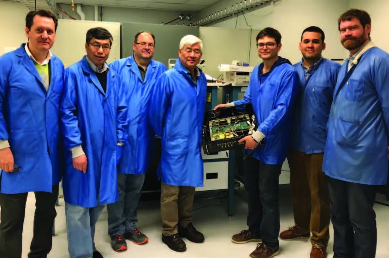 Photo of team of scientists in blue lab jackets