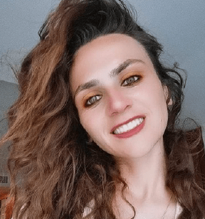 Portrait photo of a smiling young woman with long wavy brown hair