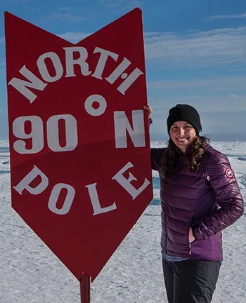 Photo of Lauren Farmer next to the North Pole sign