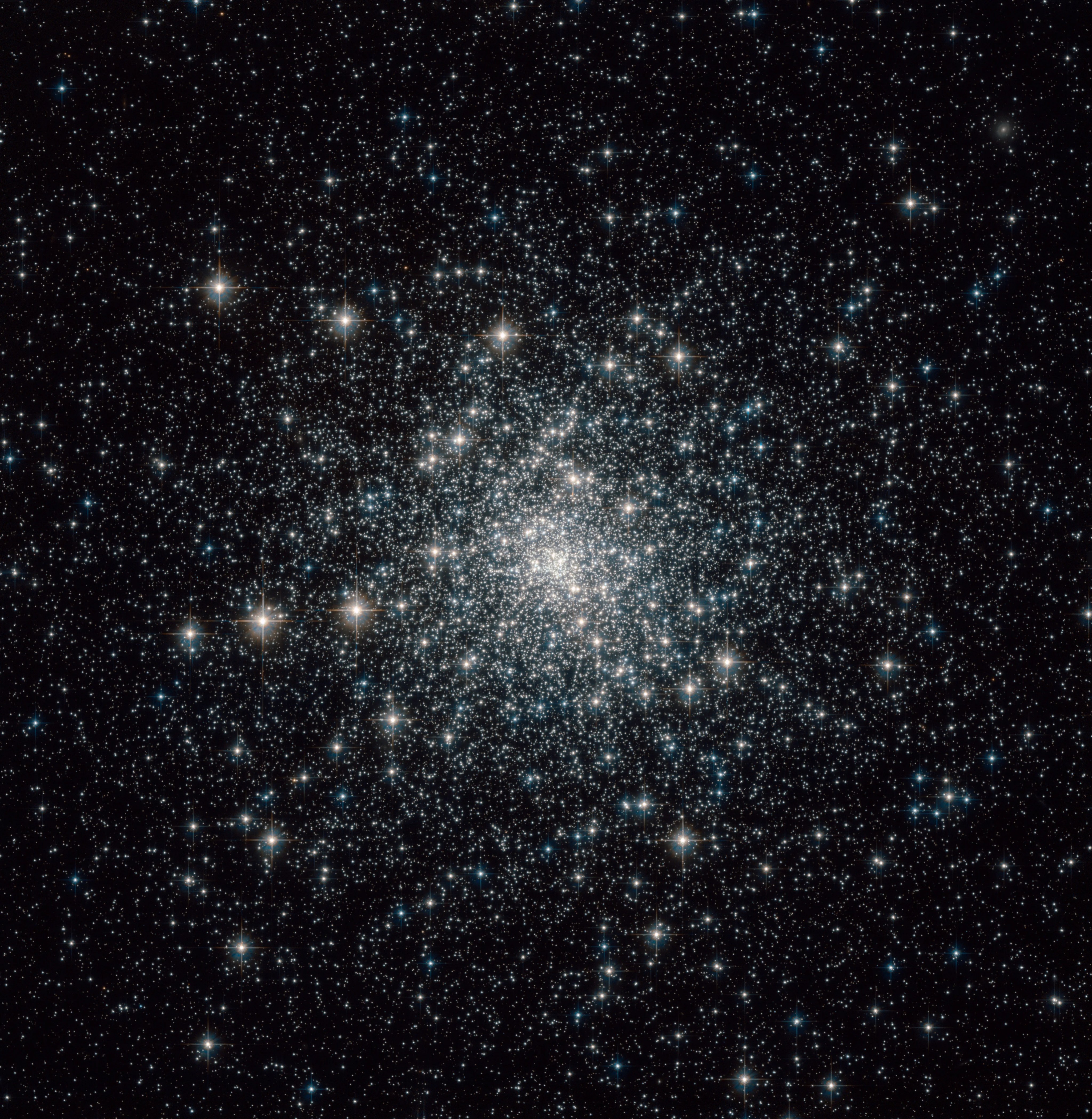 Thousands of mostly white and yellowish stars in a globular cluster.