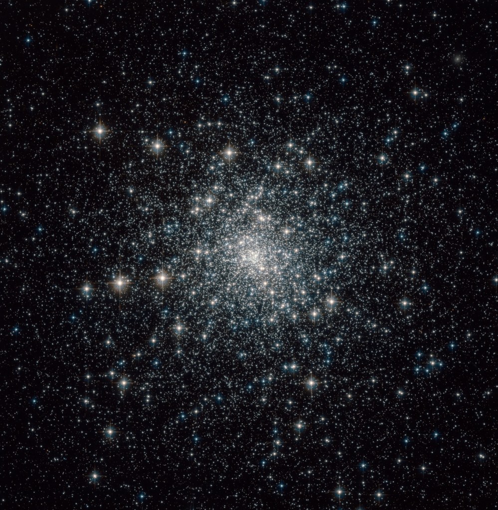 Thousands of mostly white and yellowish stars in a globular cluster.