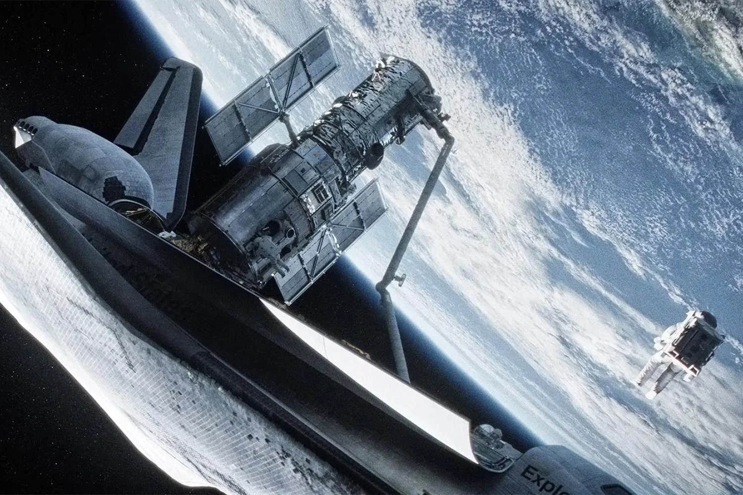 A screenshot of an artist illustration from the movie gravity of the hubble space telescope exiting a space shuttle orbiting the earth with an astronaut floating to the right