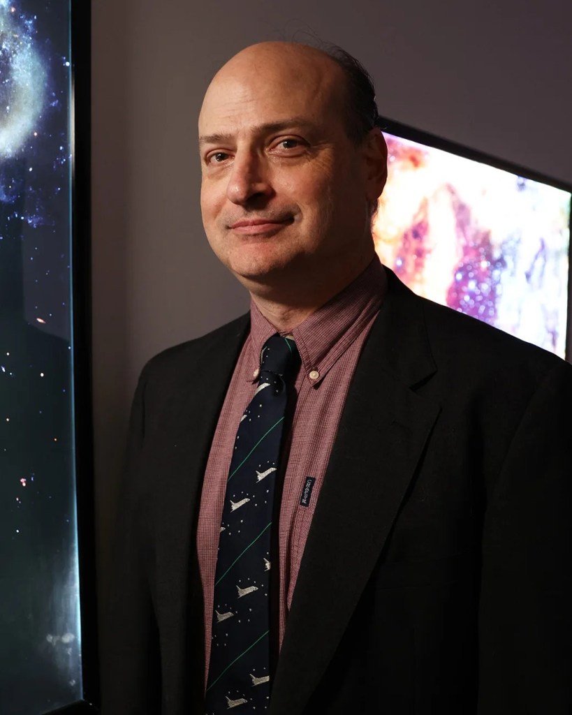 Headshot of Andy Ptak standing in front of Arp273 - The Rose Galaxies