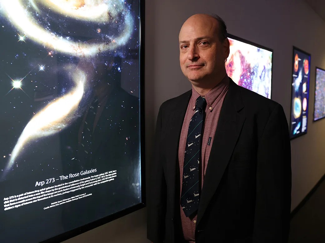 Headshot of Andy Ptak standing in front of Arp273 - The Rose Galaxies