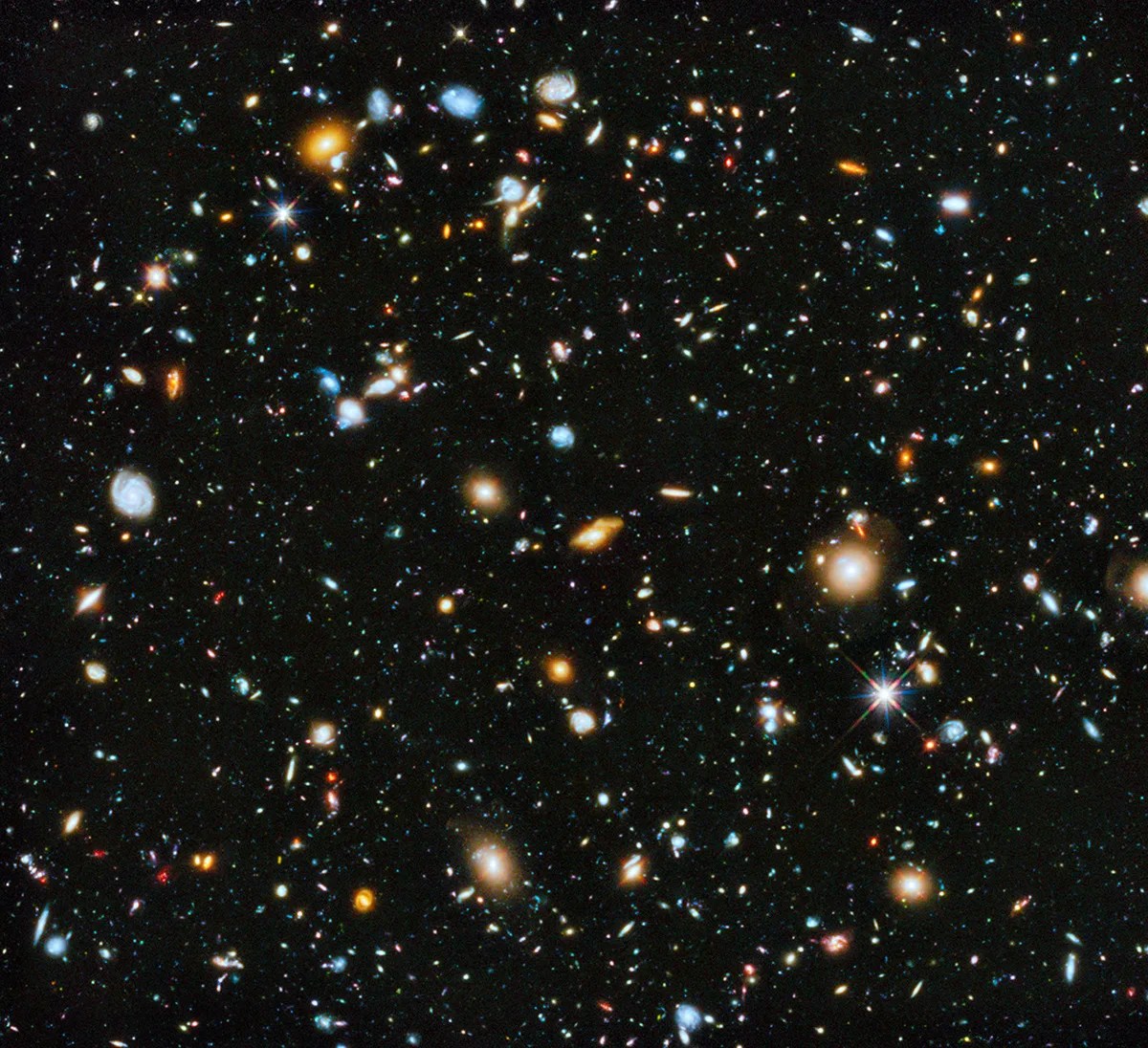 Field is filled with galaxies in colors of white, yellow, blue-white, and red; all on a black background.