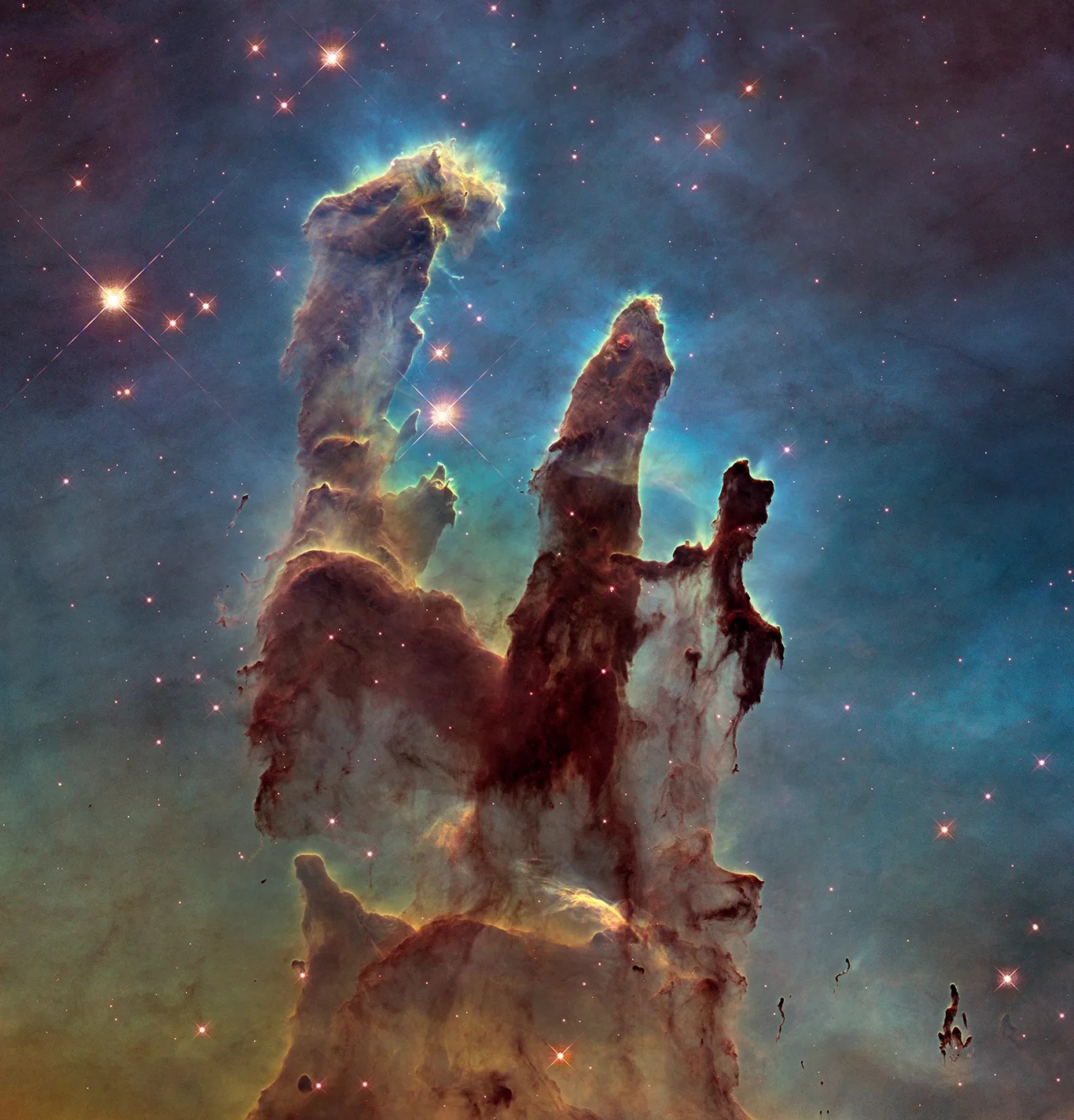 The famous Pillars of Creation revealed by the Hubble Space Telescope in high definition. Multiple pillars of brown gas and dust with potential stars in protruding fingertips, with a background of green and blue gas.