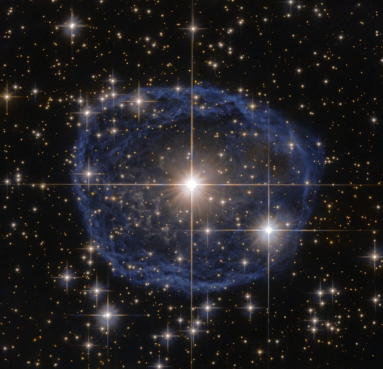 A large blue bubble with a bright star in the center on a black background filled with stars